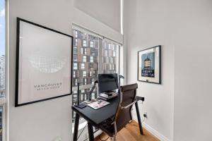 a desk with a chair in a room with a window at Beautiful Downtown Loft with full kitchen in Vancouver +24 photos