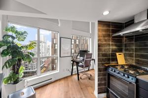 a kitchen with a large window and a table with a desk at Beautiful Downtown Loft with full kitchen in Vancouver