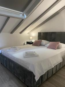 1 dormitorio con 1 cama grande con sábanas blancas y almohadas rosas en Apartment City Vibe, great location!, en Šibenik