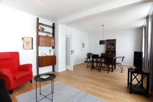 a living room with a red couch and a table at Gästewohnung Lipperland in Lage