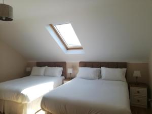 2 letti in una camera da letto con lucernario di Glenmore House - ROOM ONLY a Doolin