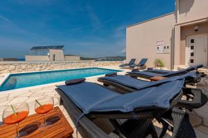 a pool with lounge chairs and a swimming pool at Villa Mona Apartments in Ražanj