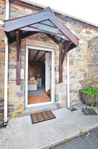 ein Steingebäude mit einer Markise über einer Tür in der Unterkunft Cosy cottage for 2, sea views, large grounds. WiFi in Newport