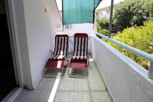 zwei Stühle auf dem Balkon eines Hauses in der Unterkunft Beautiful sea-view Apartment in Marina Croatia in Marina