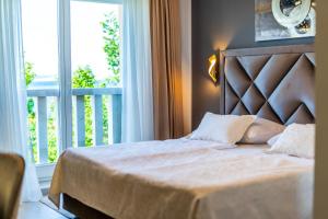 1 dormitorio con 1 cama grande y balcón en Heritage Hotel Stypia, en Crikvenica