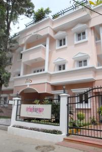 a pink building with a sign in front of it at Sterling Living Space - Residency Road in Bangalore