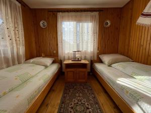 2 Einzelbetten in einem Zimmer mit Fenster in der Unterkunft Pensiunea Nechita in Şanţ