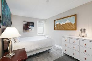1 dormitorio con 1 cama y escritorio con lámpara en Condo at Blue Mountain on Ski Run Close to Village, en Blue Mountains