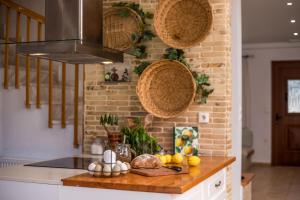 a kitchen with a counter with fruits and baskets on the wall at Emarmene Home with private pool near Rhodes Town & airport in Koskinou