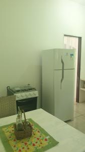 una cocina con nevera blanca y una cesta en una mesa en Apartamentos GoPipa934, en Pipa