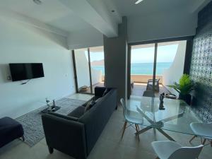 a living room with a couch and a glass table at Tramonto Resort Mazatlan in Mazatlán