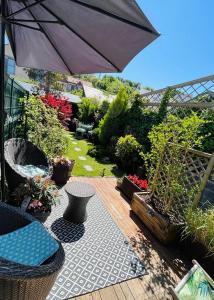 eine Terrasse mit Sonnenschirm und einigen Pflanzen in der Unterkunft Bienvenue chez Greg in Honfleur