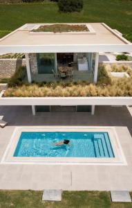 a person is swimming in a swimming pool at VARKO LUXURY SUITES in Paleros