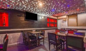 un restaurant avec un bar doté de tables et d'une télévision dans l'établissement Treebo Trend Rockland And Restaurant, à Jaipur