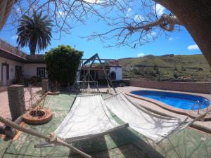 una hamaca en un patio junto a una piscina en FINCA RURAL CARDENGROS, en Tenoya