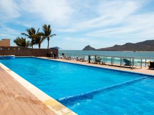 a swimming pool with the ocean in the background at Tramonto Resort Mazatlan in Mazatlán