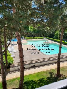 um sinal para uma piscina num parque com árvores em Apartmány LINEA Deluxe em Piešťany
