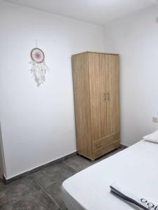 a bedroom with a bed and a wooden cabinet at דירה מקסימה in Eilat
