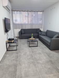 a living room with two couches and a tv at דירה מקסימה in Eilat