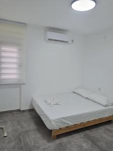 a bed in a room with a white wall at דירה מקסימה in Eilat