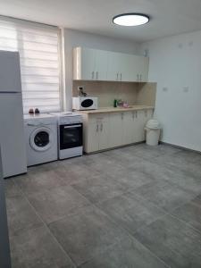 a kitchen with a stove and a washer and dryer at דירה מקסימה in Eilat