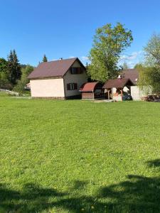 un gran campo de césped con una casa en el fondo en Bükkfői vendégház, en Borzont