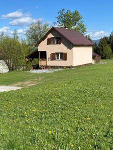 una casa con un campo de césped verde y una casa en Bükkfői vendégház, en Borzont