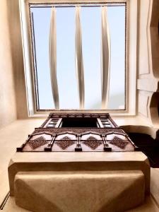 un letto posto di fronte a una finestra di Riad Sabah a Marrakech