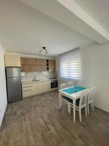 a kitchen with a table and chairs and a refrigerator at Apartman Holiday in Tivat