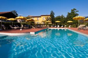 einen Pool mit Stühlen und Sonnenschirmen in einem Resort in der Unterkunft Antico Casale in Sarzana