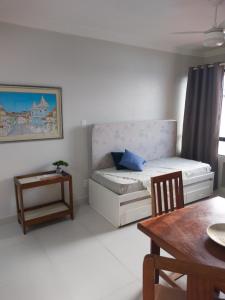 Habitación pequeña con cama, mesa y sidra de mesa en Farol Barra Flat, en Salvador
