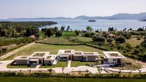 an aerial view of a large house with a view of the water at VARKO LUXURY SUITES in Paleros