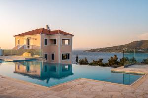 a house with a swimming pool next to the ocean at Grand View Villas in Samos