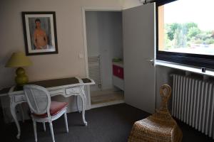 a room with a desk and a chair and a window at La Californie in Changé