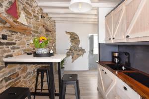 a kitchen with a table and a stone wall at Tramuntana in Ano Syros
