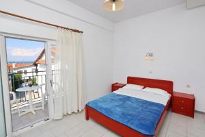 1 dormitorio con 1 cama y balcón en Spanos apartments Anna's lodge, en Polychrono