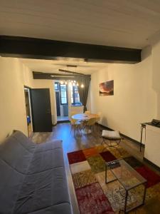 a living room with a couch and a table at En cœur de ville in Chambéry