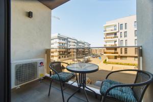 einen Balkon mit einem Tisch und Stühlen sowie Stadtblick in der Unterkunft Olive Garden at West Residence in Oradea