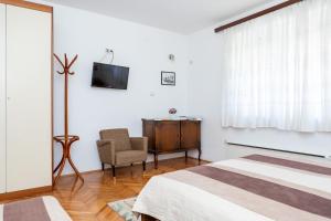 a bedroom with a bed and a chair and a television at Smeštaj Luka in Soko Banja