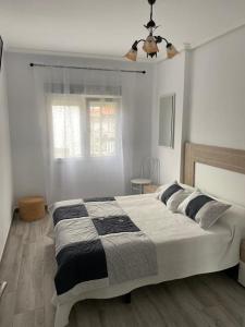 蘇安塞斯的住宿－NUEVO!!! PISO CENTRICO EN SUANCES -Sol Luxury-，一间卧室设有一张大床和一个窗户。