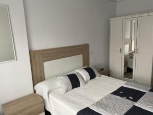 1 dormitorio con 1 cama grande y espejo en NUEVO!!! PISO CENTRICO EN SUANCES -Sol Luxury- en Suances