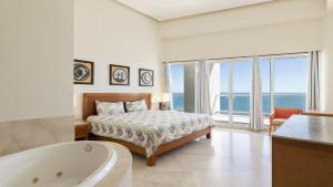 a bedroom with a bed and a bath tub and a bath tub at Luna Blanca Penthouse by Kivoya in Puerto Peñasco
