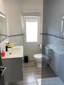 uma casa de banho com 2 lavatórios, um WC e uma janela em NUEVO!!! PISO CENTRICO EN SUANCES -Sol Luxury- em Suances