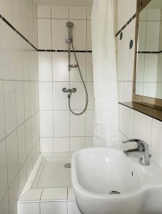 a white bathroom with a sink and a shower at Hotel Bistrot FINE in Anglet