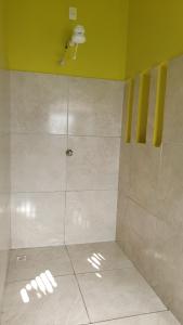 y baño con ducha y paredes de color amarillo. en Apartamentos GoPipa934, en Pipa 33 fotos más