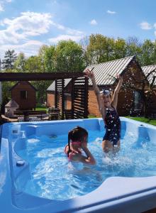 dwoje dzieci bawi się w basenie w obiekcie Lawendowo- sauna jacuzzi domki w ogrodzie i apartamenty w kamienicy w mieście Sandomierz
