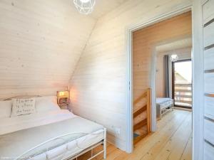 a bedroom with a bed in a room with wooden walls at Seaside domki in Mielno +33 photos