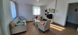 a living room with a couch and chairs and a tv at Family Apartment Marea in Nova Vas