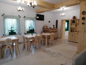 a dining room with tables and chairs and a kitchen at Căsuța din Deal in Moisei
