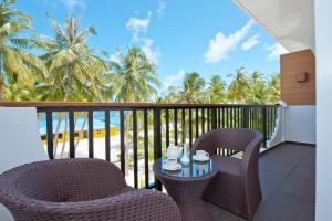 
a patio area with chairs, tables and umbrellas at Crystal Sands in Maafushi
